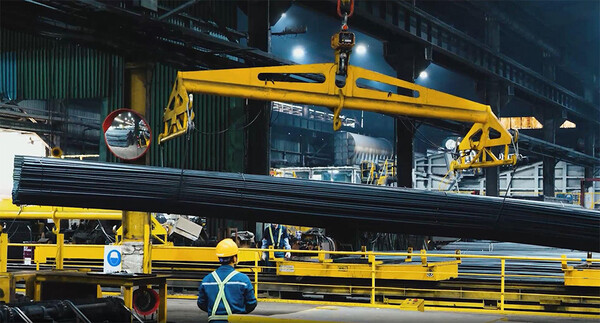 경북 포항 화진철강 공장에서 작업자가 크레인으로 철근을 옮기고 있다.