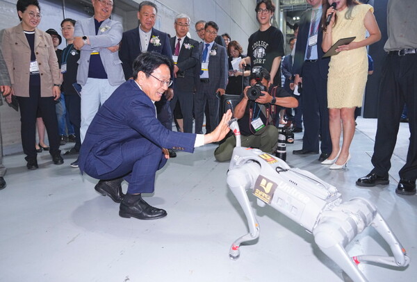 강기정 광주광역시장이 지난 6월 27일 김대중컨벤션센터에서 열린 ‘2024 광주미래산업엑스포 개막식’에 참석해 부스에 마련된 로봇강아지와 하이파이브를 하고 있다.