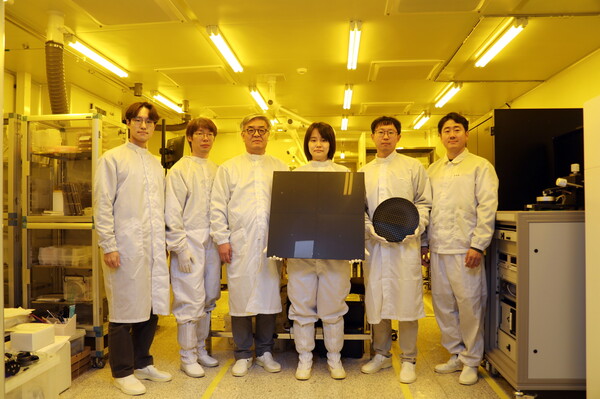 한국기계연구원 자율제조연구소 반도체장비연구센터 송준엽 연구위원 연구팀(왼쪽부터 오승진 선임연구원, 이재학 책임연구원, 송준엽 연구위원, 박아영 선임연구원, 문현규 선임연구원, 한성흠 책임연구원)이 ㈜네페스와 공동 개발한 대면적 사각형 패널과 기존의 원형 웨이퍼를 비교하여 들고 있다.