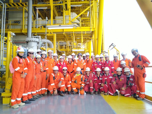 한화오션 및 NOC 관계자들이 알샤힌(Al-Shaheen) 유전 지역에 설치된 고정식 원유생산설비에서 기념촬영을 하고 있다.