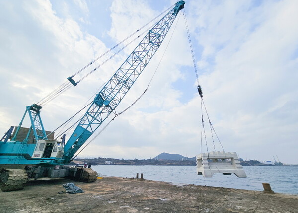 제주 신촌리 앞바다 사업대상지에 크레인으로 인공어초를 투입하고 있다.