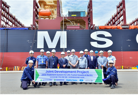 건조 중인 LNG 연료 추진선의 증발가스를 육상 도시가스로 재활용하는 기술 실증 진행 현장에서 관계자들이 기념사진을 촬영하고 있다.